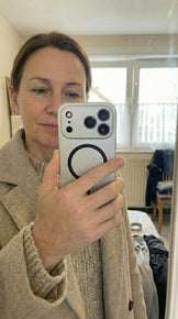 Funda metálica plateada para iPhone frente al espejo